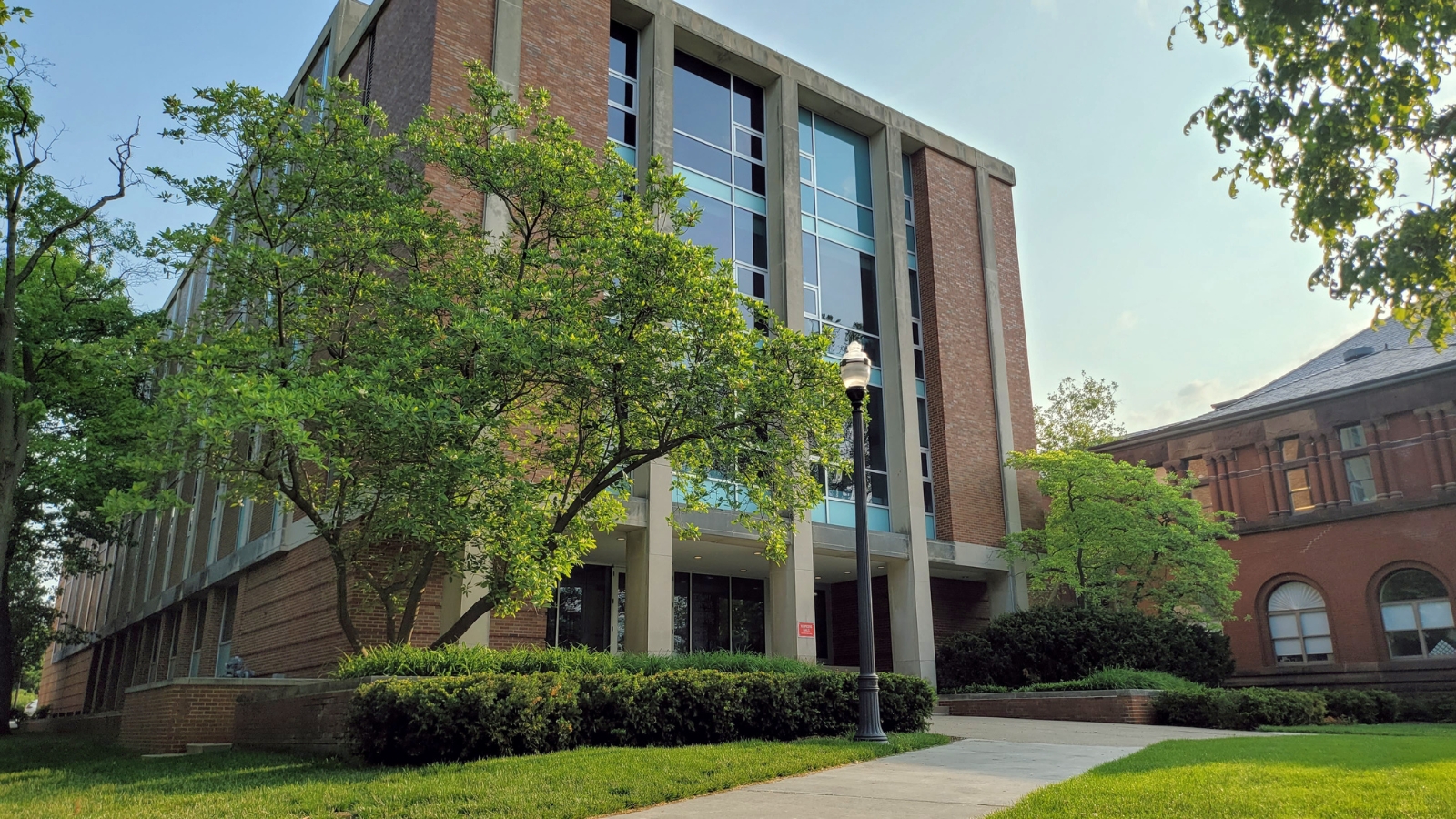 Image of front of Hopkins Hall, a squared brick and concrete building with windows in front/