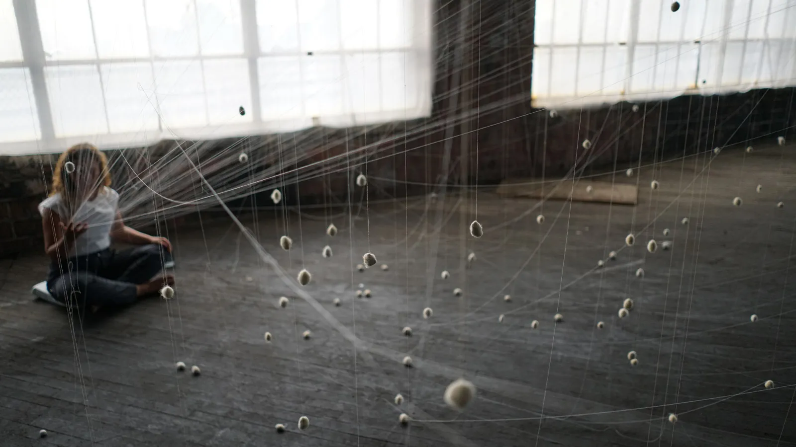 nstallation view of a durational performance and site integrated sculpture with strings and wool. 