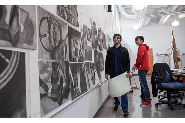 Students hanging drawings