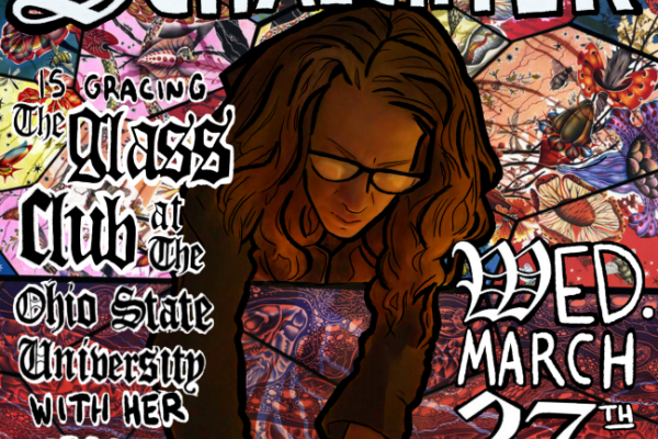 woman with long hair and glasses bent over a stained glass surface working