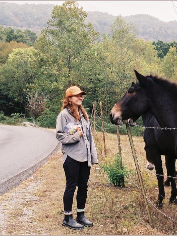 Image of Maria Conlon facing a dark brown horse