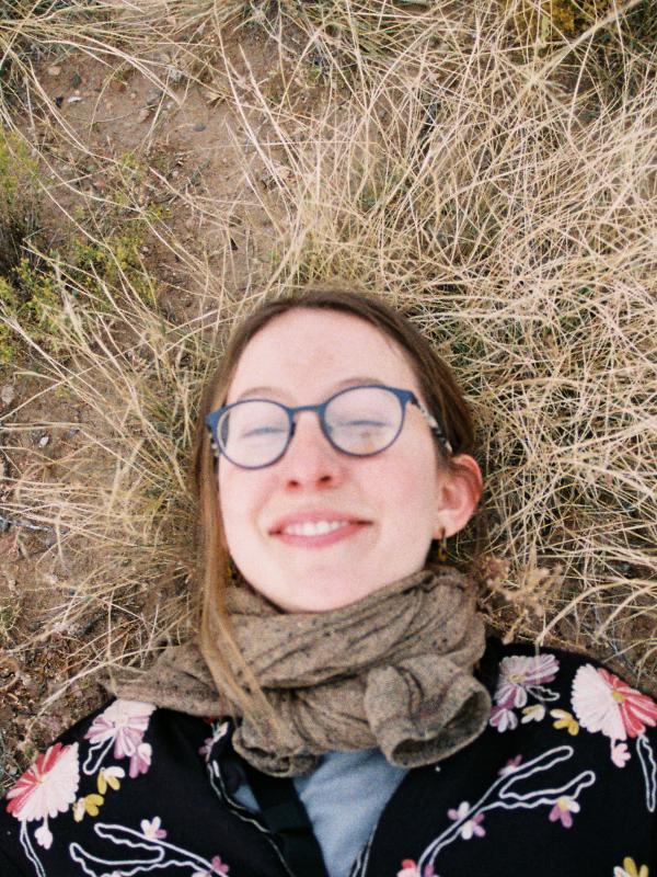 a person with glasses laying in the grass