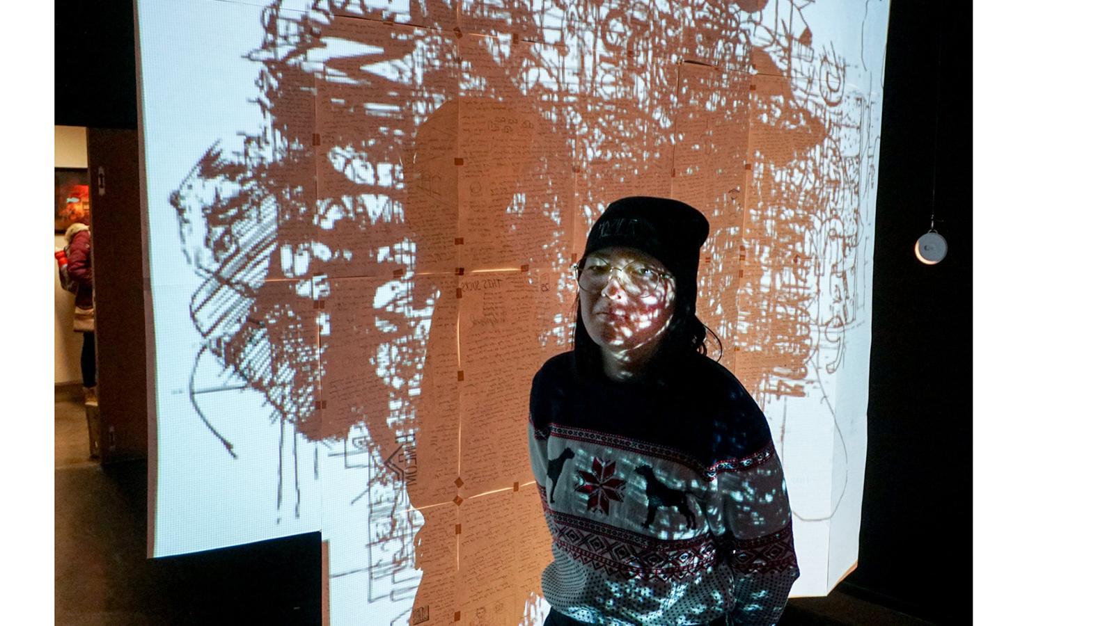 student in front of projected work